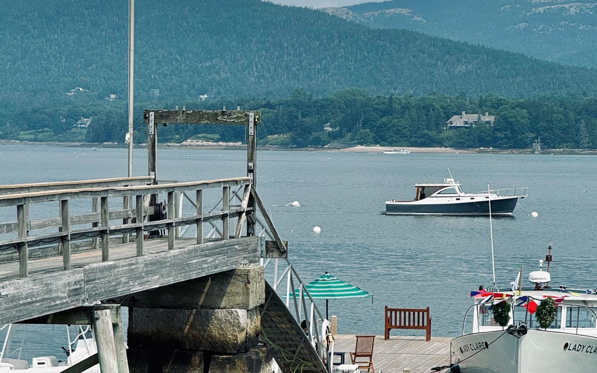 A lobster pound on the Maine coast with picnic tables and boats in the harbor